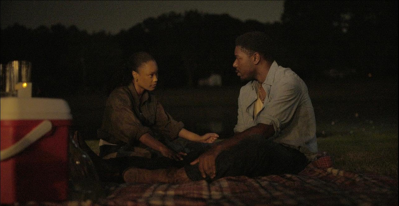 Darren and Anissa sitting together outdoors at night